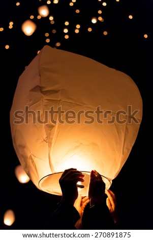 Make A Wish.Yellow lantern in human hands on dark background