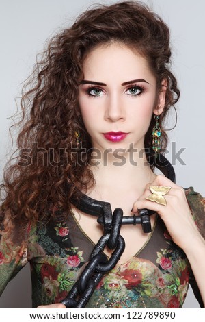 Portrait of young beautiful woman with heavy chain on her neck