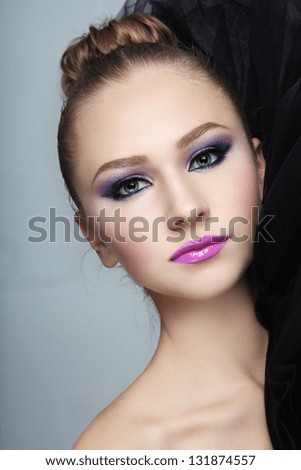 Portrait of young beautiful girl with fancy make-up and hair bun