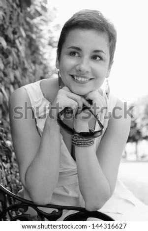 Black and white outdoor emotional portrait of young beautiful laughing woman