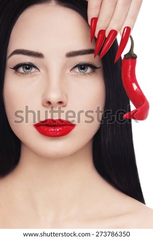 Portrait of young beautiful brunette with red lipstick, long stiletto nails and hot chili pepper in her hand over white background