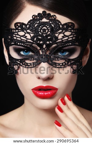 Portrait of young beautiful blue-eyed woman in black lacy mask