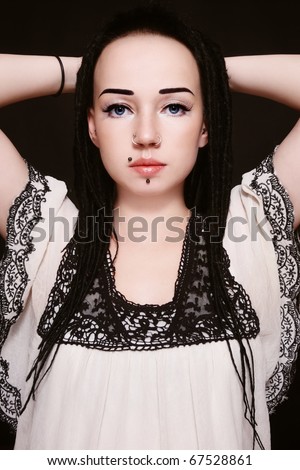 Young beautiful gothic woman with fancy make-up, dreads and piercing