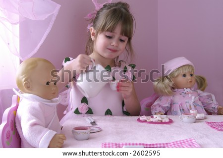 A young girl having a tea party with her baby dolls