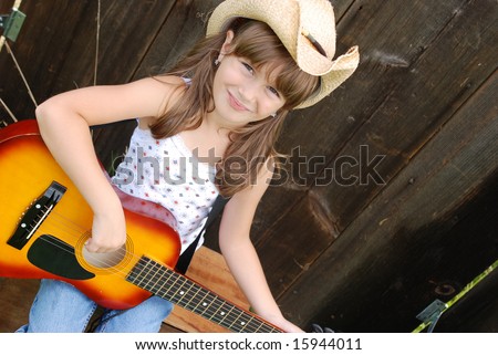 A cute young girl playing the guitar
