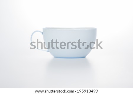 Studio shot on a white background of a stylish modern plain white cup with a handle for serving hot beverages such as coffee and tea, with copyspace