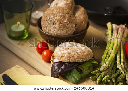 Close up Gourmet Healthy Food with Bread and Veggies on Wooden Board, Emphasizing Leafy Vegetables, Asparagus and Tomatoes