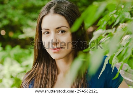 Young beautiful caucasian woman smiling no teeth park soft summer nature portrait bokeh