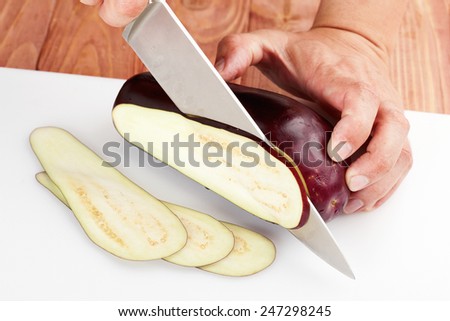 cutting fresh eggplant on a cutting board. preparation of food indredients