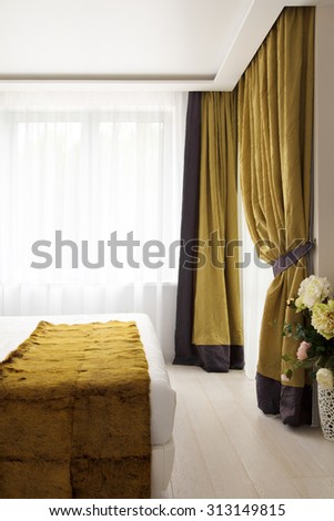 Luxury bedroom with two large windows. The cozy bedroom