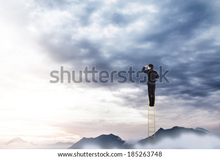 Businessman climbing on a ladder over mountain looking ahead