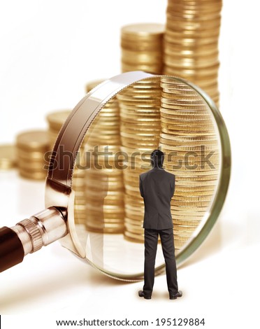 Businessman checks the money with magnifying glass