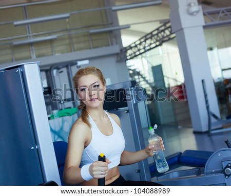 Girl in fitness club with bottle of water in hand