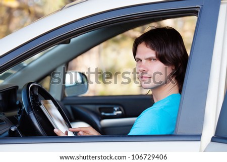 the guy sitting in the car with the keys in the hands