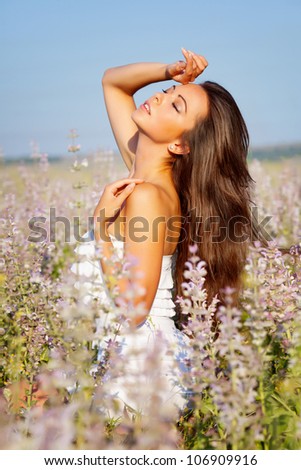 smiling beautiful brunette in the flowers  field