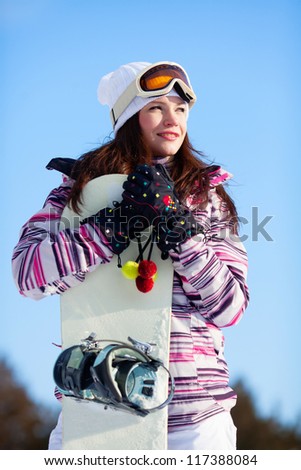 Beautiful girl in winter forest with snowboard