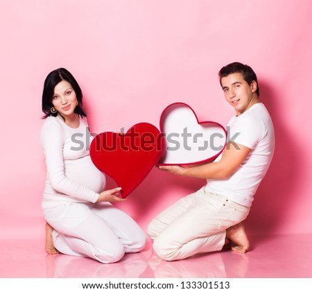 Pregnancy young woman with man in studio