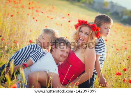 Family of four person playing on the poppy field