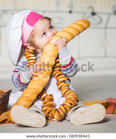 Little boy in baker costume with long loaf