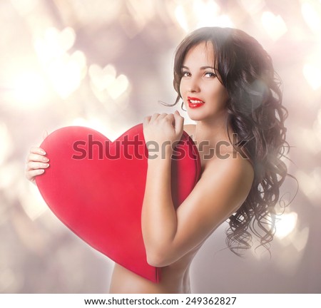 Beautiful nacked girl with big heart in hands portrait in studio.