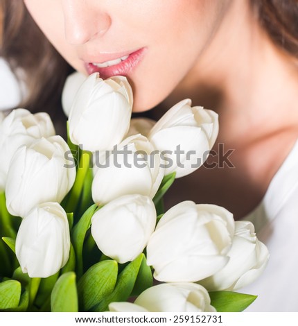 Young beautiful woman with bouquet of tulip flowers, portrait in studio