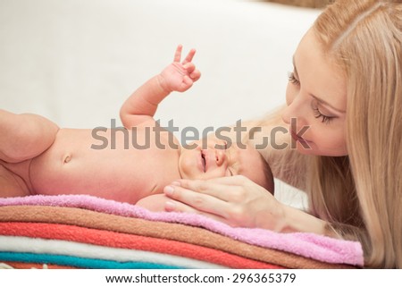 Mother and her Newborn Baby. Happy Mother and Baby kissing and hugging. Maternity concept. Parenthood. Motherhood