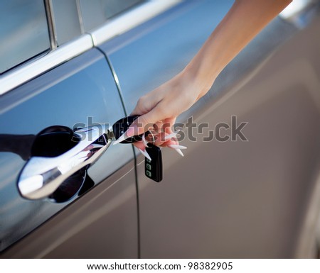 woman hand opening car door with key