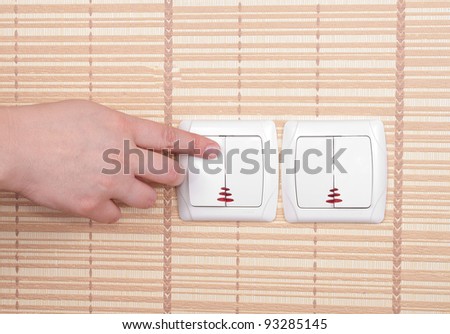 Hand pressed to switch on the wall