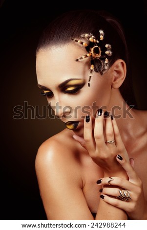 Attractive caucasian female studio portrait with spider on her face