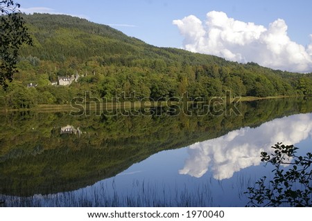 Scottish Castle reflected in Loch on Sunny Day