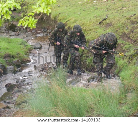 British soldiers move along river bed on training exercise