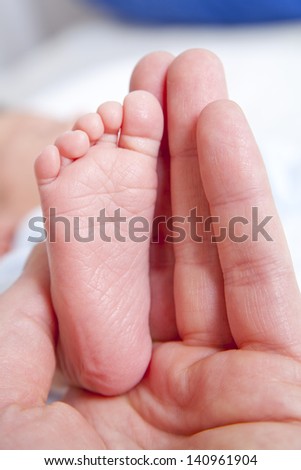 cute baby foot on his father\'s hand