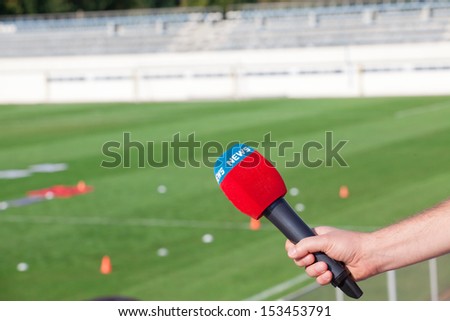 hand holding microphone for interview during a football mach