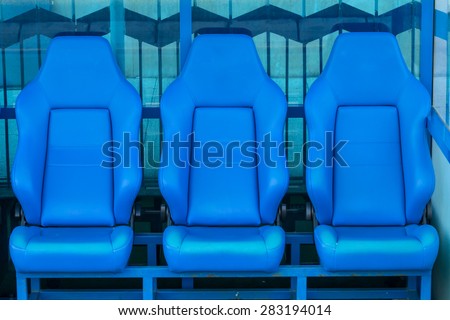 Empty coach and reserves blue bench on a football stadium