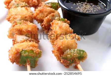 Close up of chicken Kushi sticks on a plate with dipping sauce.