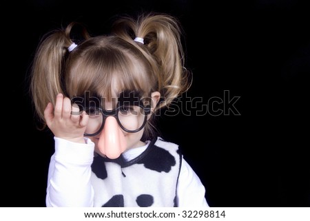 Little girl wearing silly mustache disguise