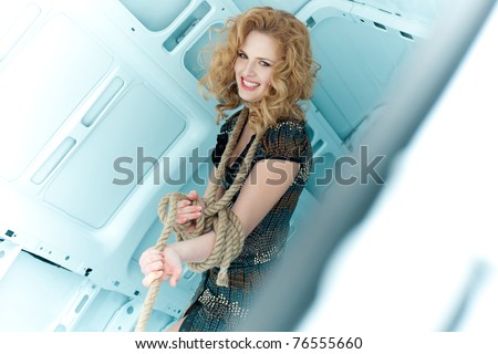 Pretty young woman in ropes in cargo van inside
