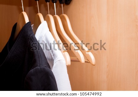 A row of shirts hanging in the closet.