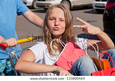 boy and girl  with shopping trolley full of purchases in the street