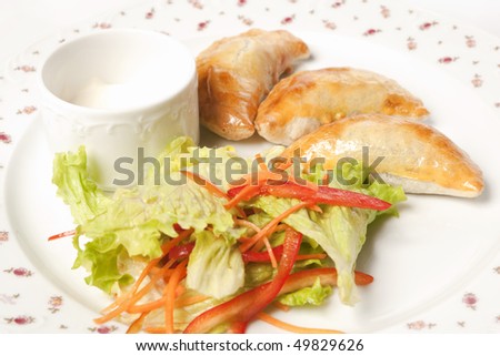 Pies, sour cream and there is some salad