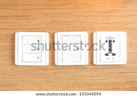 Socket and switches on wood background.
