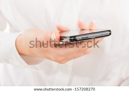 Business woman with young hands and beautiful nails using mobile smart phone with touch screen