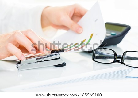 Close-up of female hand stapling the documents
