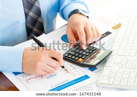 business man at workplace with pen, keyboard, calculator