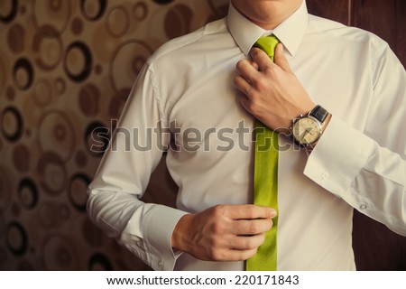 Young Business Man Fixing his Tie