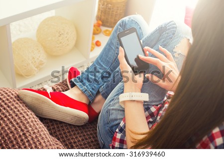 Woman at home relaxing on sofa couch reading email on mobile wifi connection
