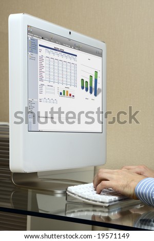 Men at work on a modern white computer. Glass desk. Diagram on a screen.