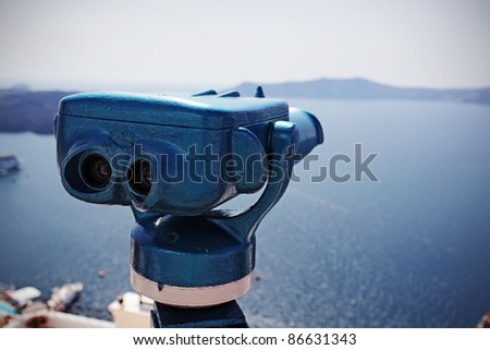 Coin operated binocular against harbor of Fira, Santorini island, Greece.