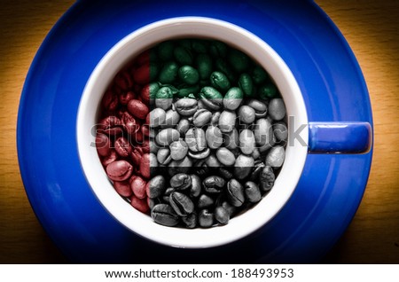cup with coffee grains. Flag of United Arab Emirates on the coffee. Popularity of coffee in this country is very high.