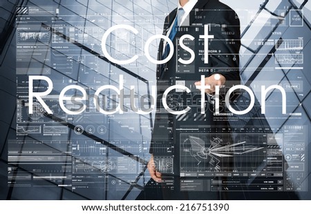businessman presenting Cost Reduction text, graphs and diagrams with skyscraper in background, business concept